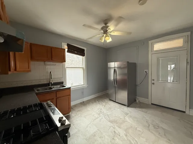 a kitchen with stainless steel appliances granite countertop a refrigerator and a stove top oven