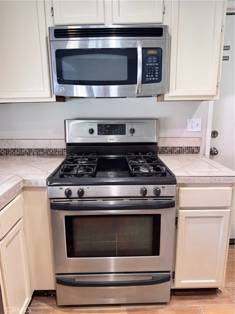 30628 Moontide Court Temecula, CA 92592 - Photo 10 of 53 a stove top oven sitting inside of a kitchen and white cabinet