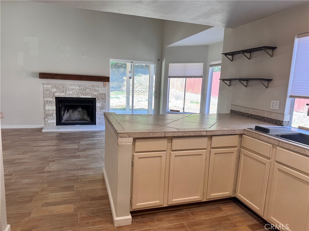 30628 Moontide Court Temecula, CA 92592 - Photo 11 of 53 a kitchen with white cabinets and a fireplace