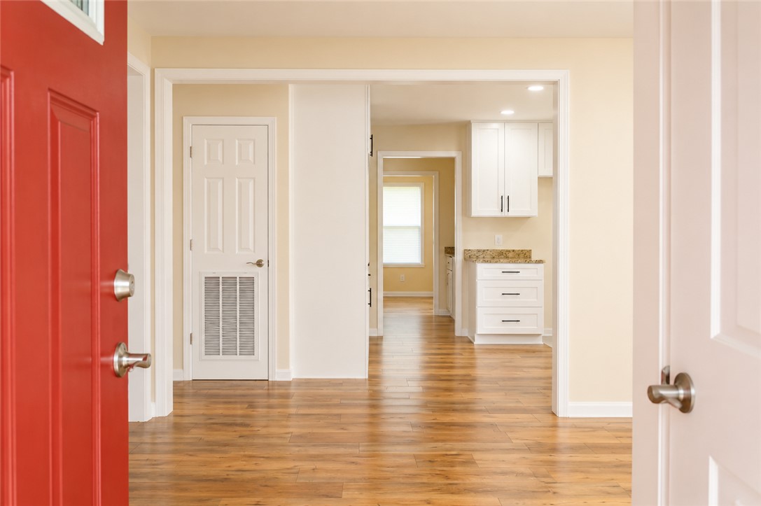 605 Hampton Street Iva, SC 29655 - Photo 4 of 16 A welcoming entry, with durable hardwood flooring, introduces an open-concept living space and kitchen.