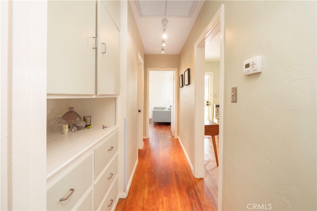 4290 Oakwood Place Riverside, CA 92506 - Photo 15 of 41 a hallway with white cabinets and wooden floor