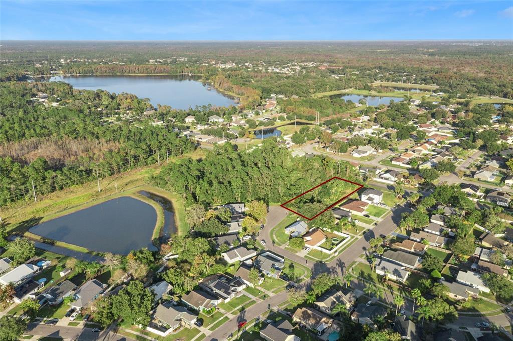 an aerial view of residential houses with outdoor space and trees