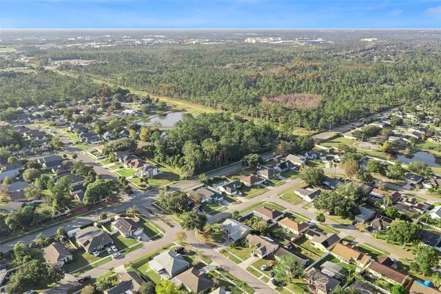 an aerial view of residential houses with outdoor space and trees