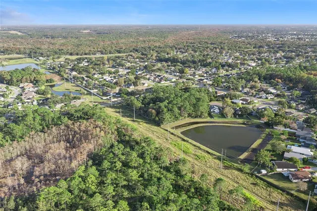 an aerial view of residential houses with outdoor space and trees