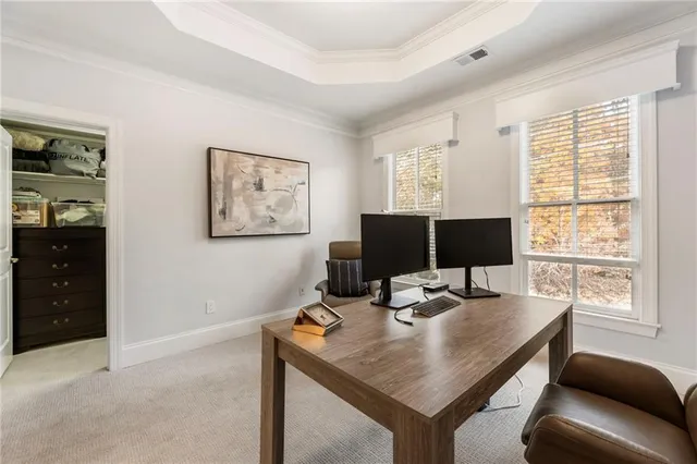 a view of a workspace with furniture and a window
