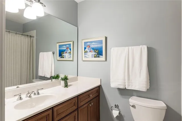 a bathroom with a sink vanity granite and toilet