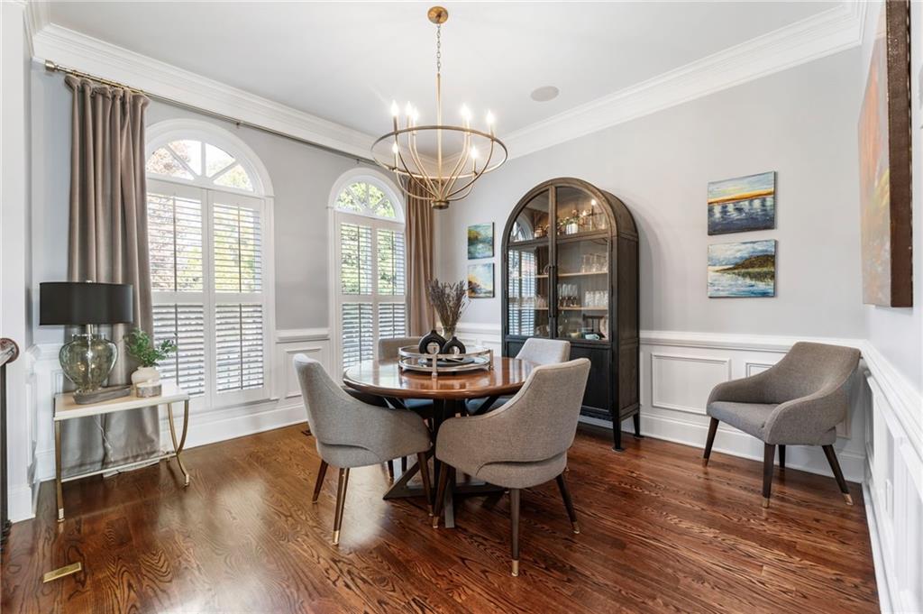 3611 Habersham Road Northwest Atlanta, GA 30305 - Photo 5 of 44 a dining room with wooden floor a chandelier a wooden table and chairs