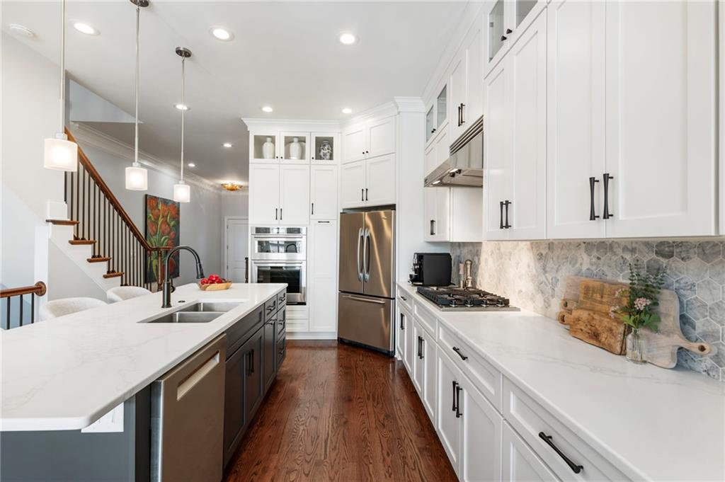 3611 Habersham Road Northwest Atlanta, GA 30305 - Photo 10 of 44 a kitchen with stainless steel appliances kitchen island granite countertop a sink a stove a refrigerator cabinets and a dining table