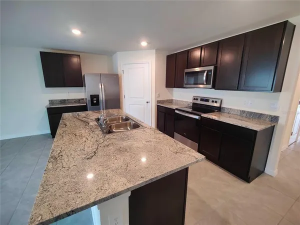 a kitchen with stainless steel appliances a sink stove and refrigerator