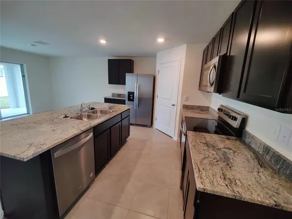 a kitchen with a sink stove and refrigerator