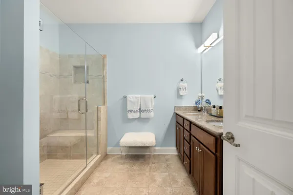a spacious bathroom with a granite countertop double vanity sink and mirror