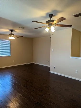 a view of a room with wooden floor fan and window