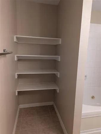 a view of walk in closet with empty racks