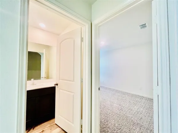 a view of hallway with sink and mirror