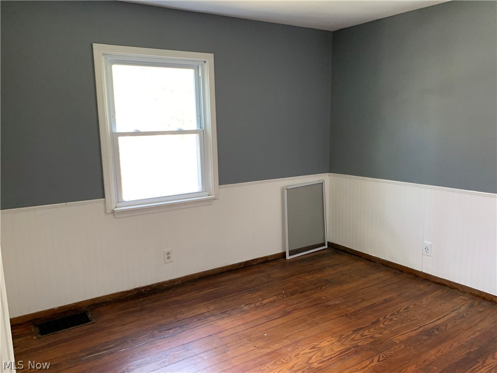 176 North Seneca Street Rittman, OH 44270 - Photo 9 of 14 Unfurnished room with plenty of natural light and dark hardwood / wood-style flooring