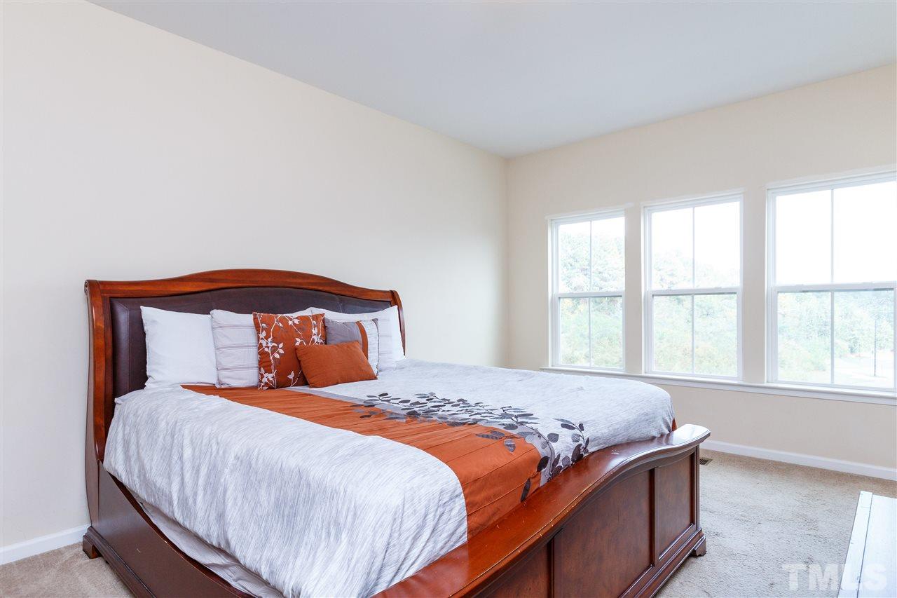 1305 Rodessa Run Raleigh, NC 27607 - Photo 16 of 25 Spacious master suite with beautiful natural light, connecting master bath, and walk in closet with wooden shelving.