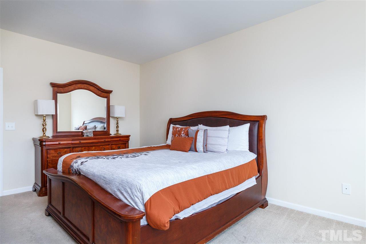 1305 Rodessa Run Raleigh, NC 27607 - Photo 17 of 25 Spacious master suite with beautiful natural light, connecting master bath, and walk in closet with wooden shelving.