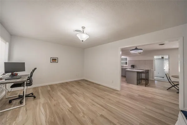 a kitchen with stainless steel appliances a table chairs and a refrigerator