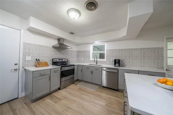 a view of a hallway with wooden floor and a bathroom
