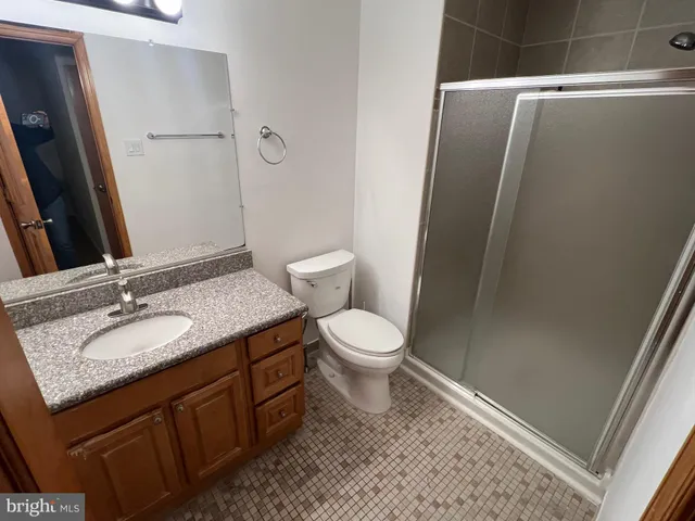 a bathroom with a granite countertop sink toilet and shower
