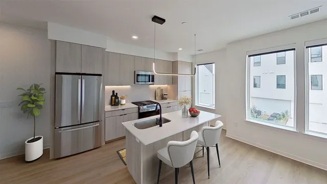 a kitchen with stainless steel appliances a refrigerator and a table