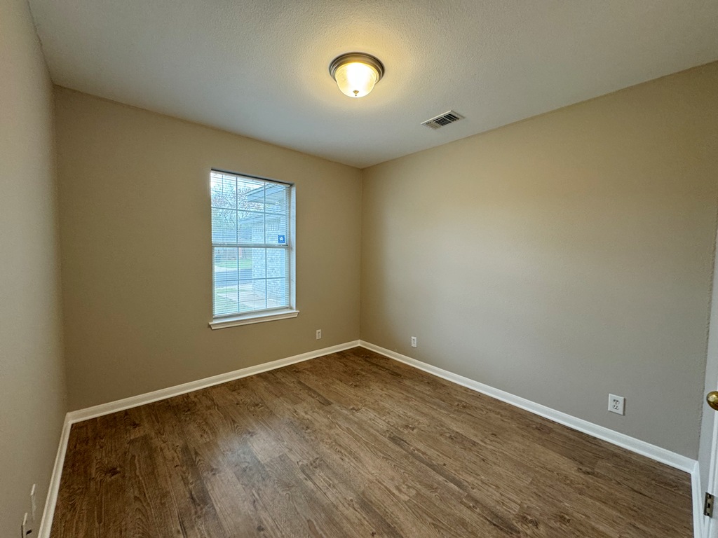 219 Crystal Knoll Boulevard Georgetown, TX 78626 - Photo 21 of 32 an empty room with wooden floor and windows