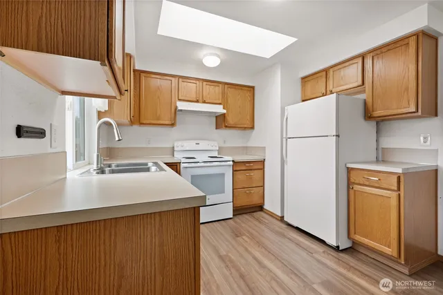 a kitchen with cabinets appliances a sink and a counter space