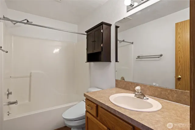 a bathroom with a granite countertop sink toilet a mirror and shower