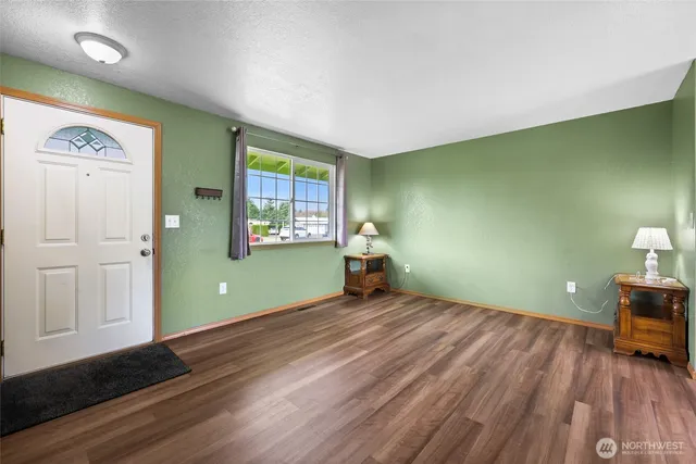 a view of empty room with window and wooden floor
