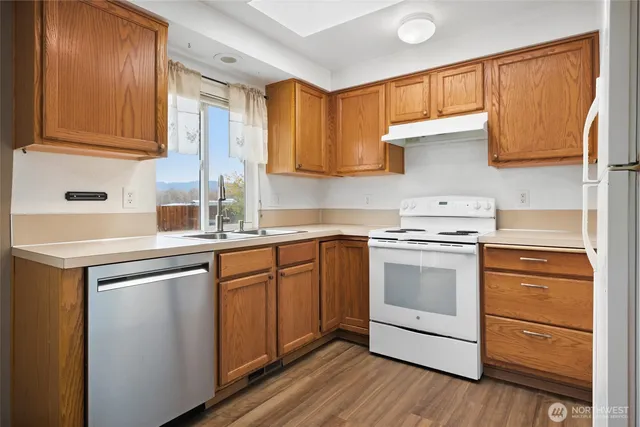 a kitchen with stainless steel appliances granite countertop a sink stove and cabinets