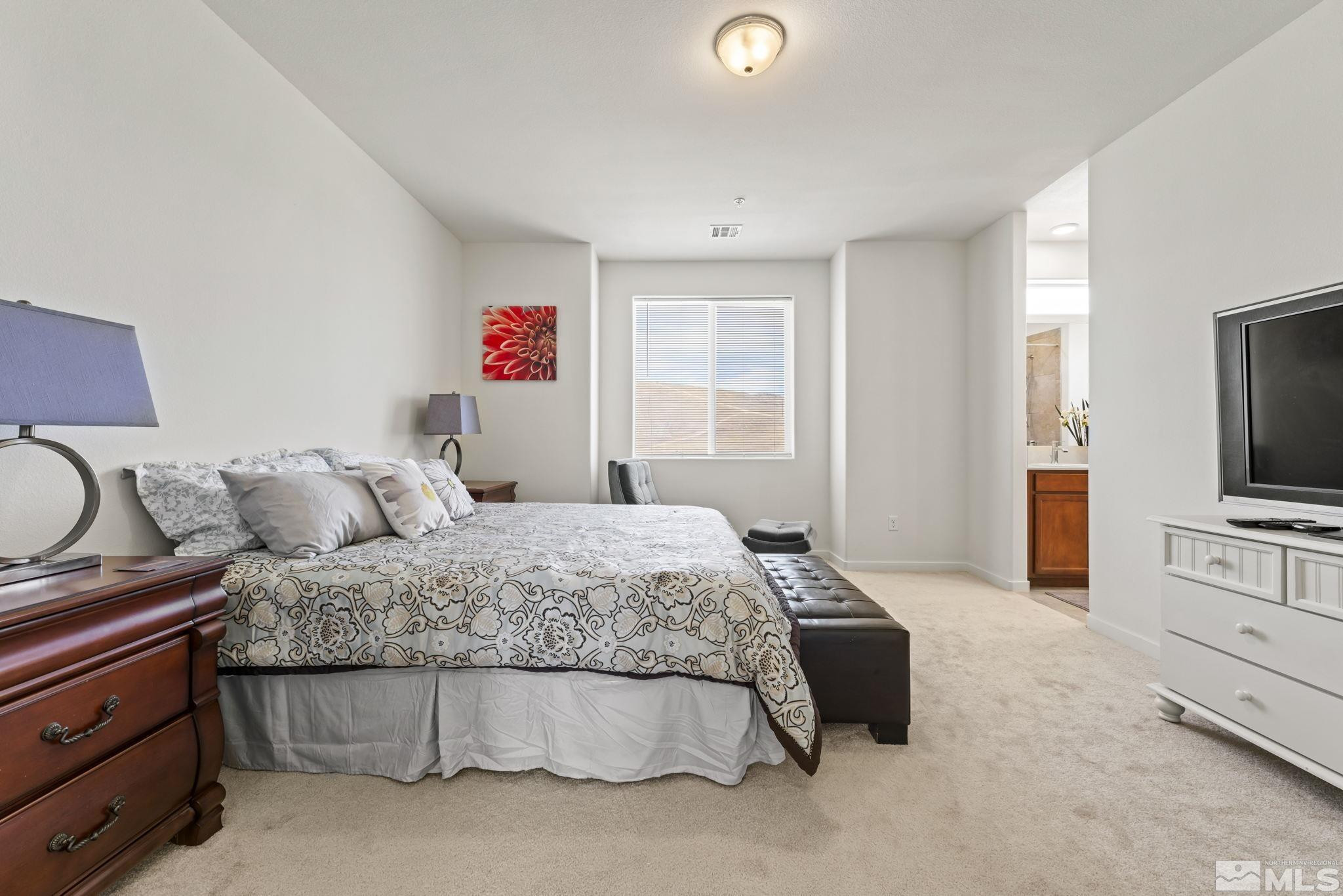 4928 Black Falcon Way Sun Valley, NV 89433 - Photo 12 of 32 a bedroom with a bed and a flat screen tv