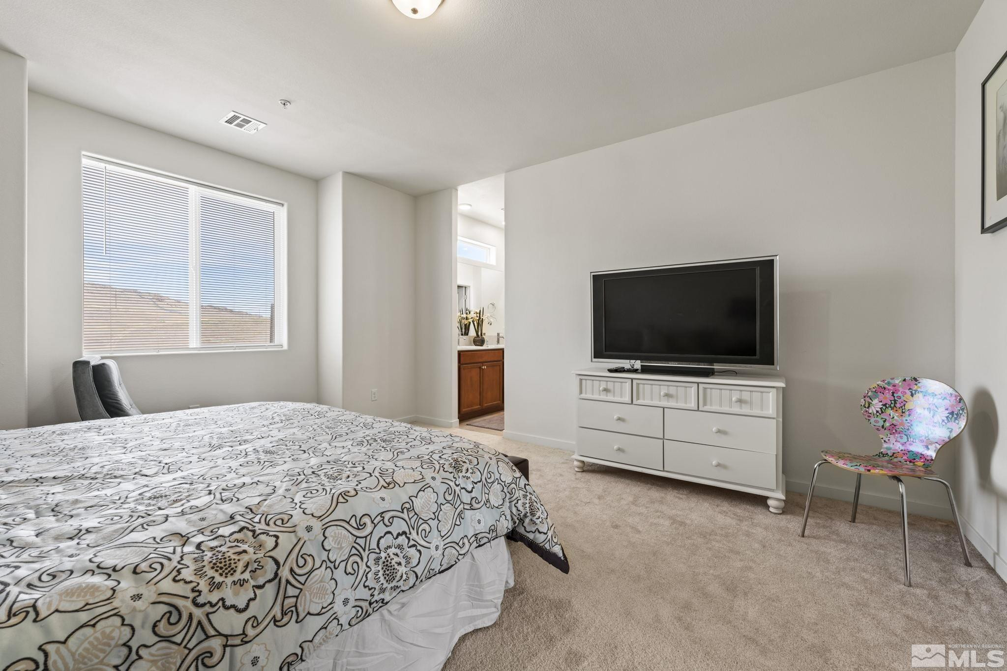 4928 Black Falcon Way Sun Valley, NV 89433 - Photo 13 of 32 a bedroom with a bed and a flat screen tv