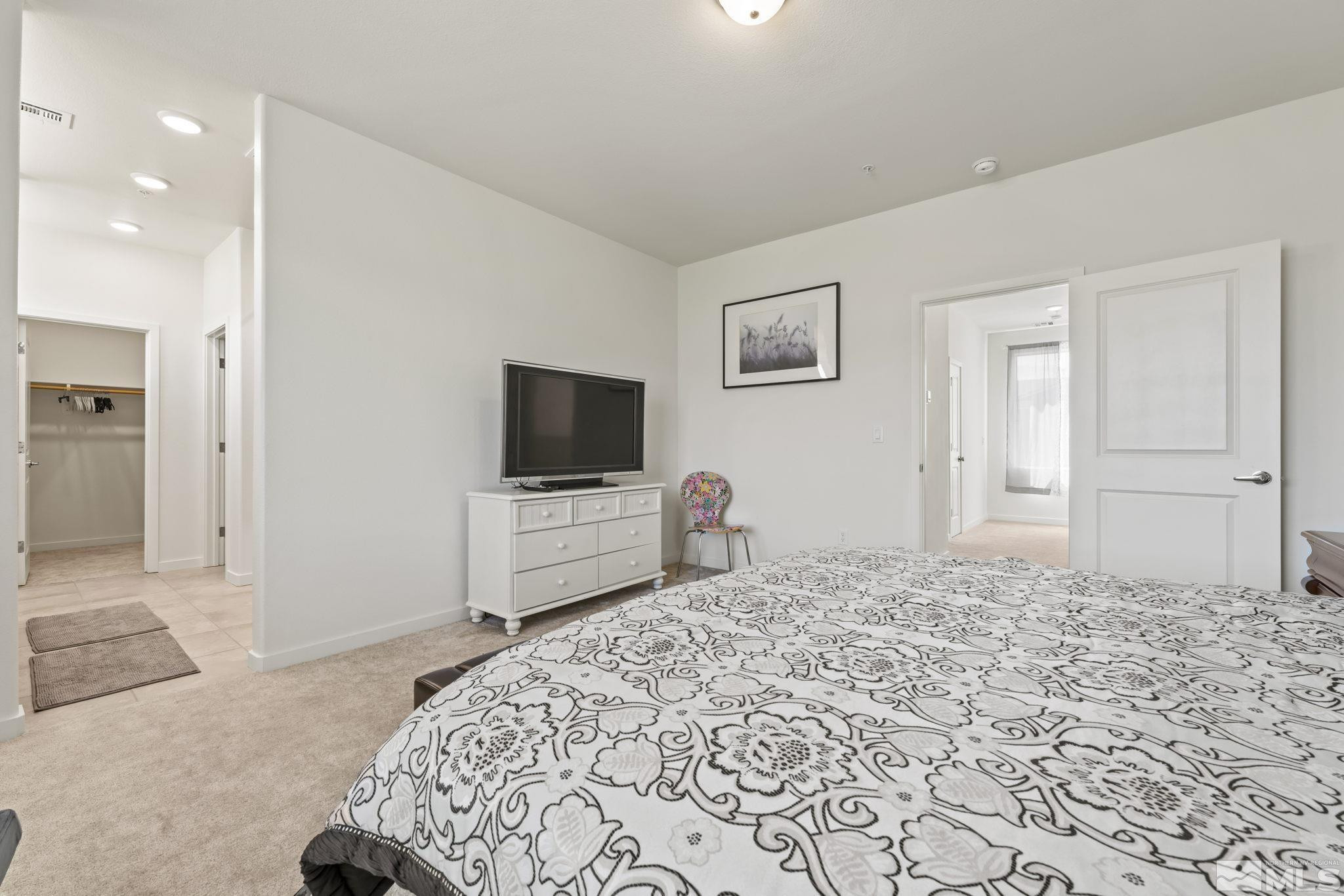 4928 Black Falcon Way Sun Valley, NV 89433 - Photo 14 of 32 a bedroom with a bed and a flat screen tv