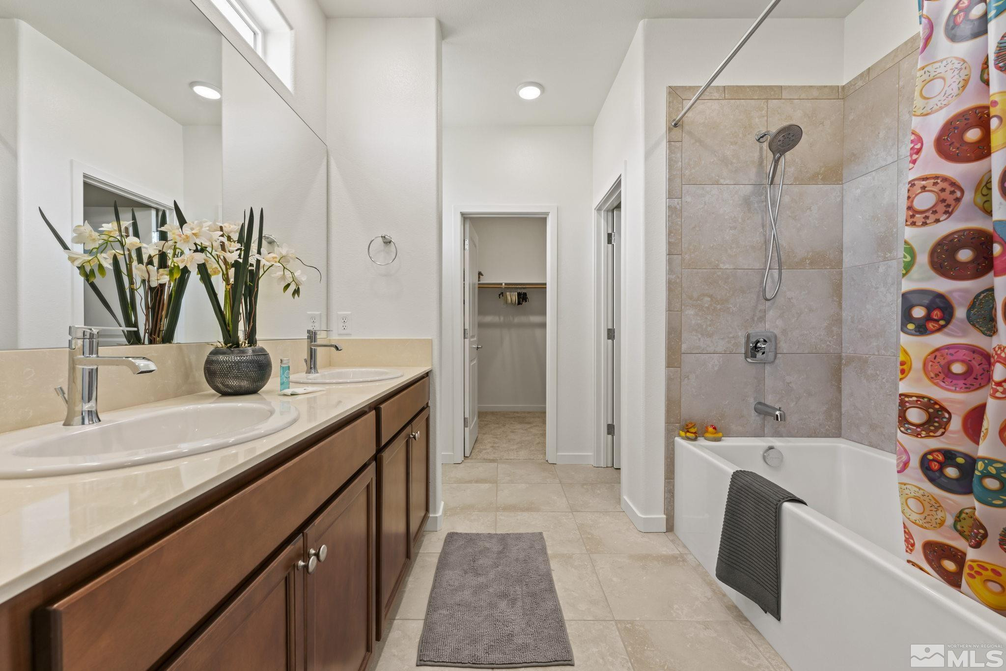 4928 Black Falcon Way Sun Valley, NV 89433 - Photo 15 of 32 a bathroom with a tub sink and mirror