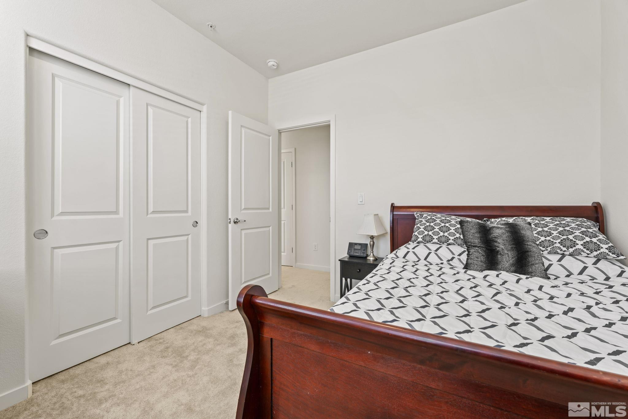 4928 Black Falcon Way Sun Valley, NV 89433 - Photo 18 of 32 a bedroom with a large bed and a shower