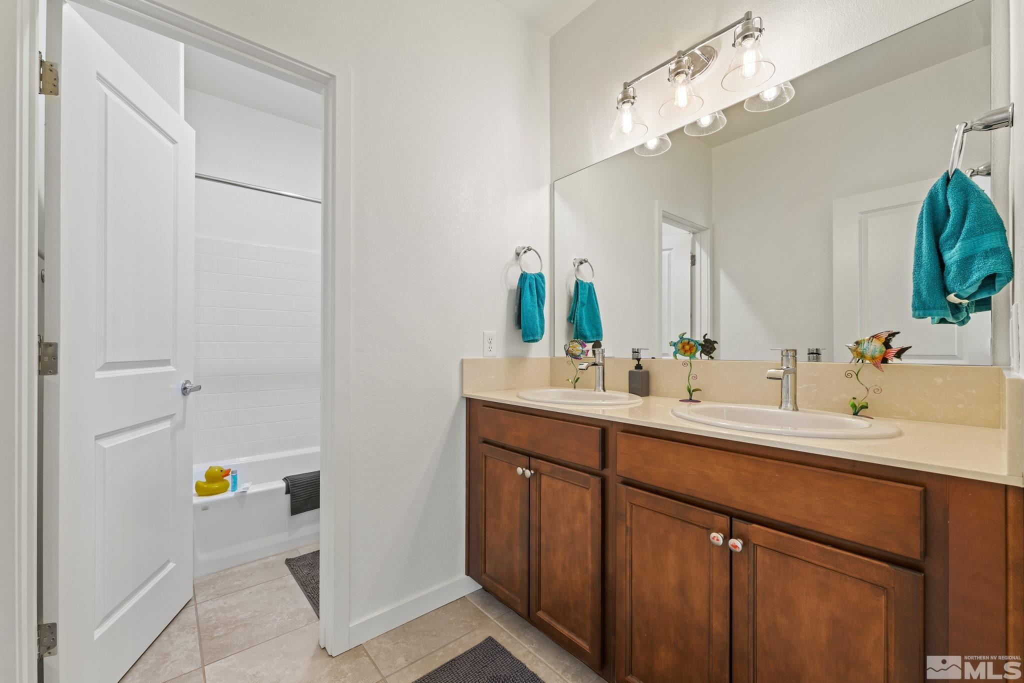 4928 Black Falcon Way Sun Valley, NV 89433 - Photo 19 of 32 a bathroom with a sink and a mirror