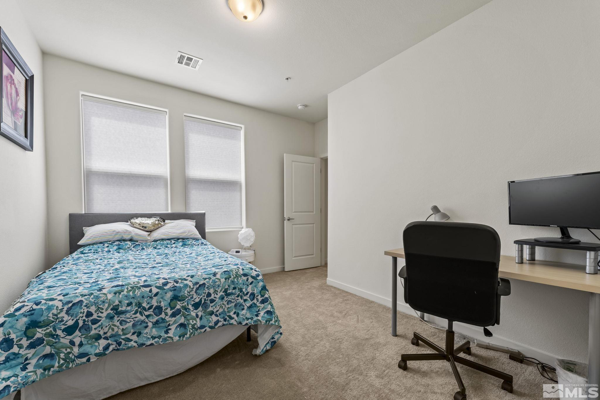 4928 Black Falcon Way Sun Valley, NV 89433 - Photo 21 of 32 a bedroom with a bed and a desk