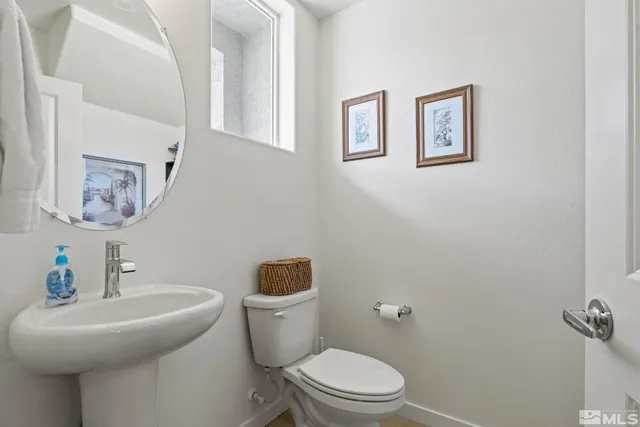 a white toilet sitting next to a bathroom sink