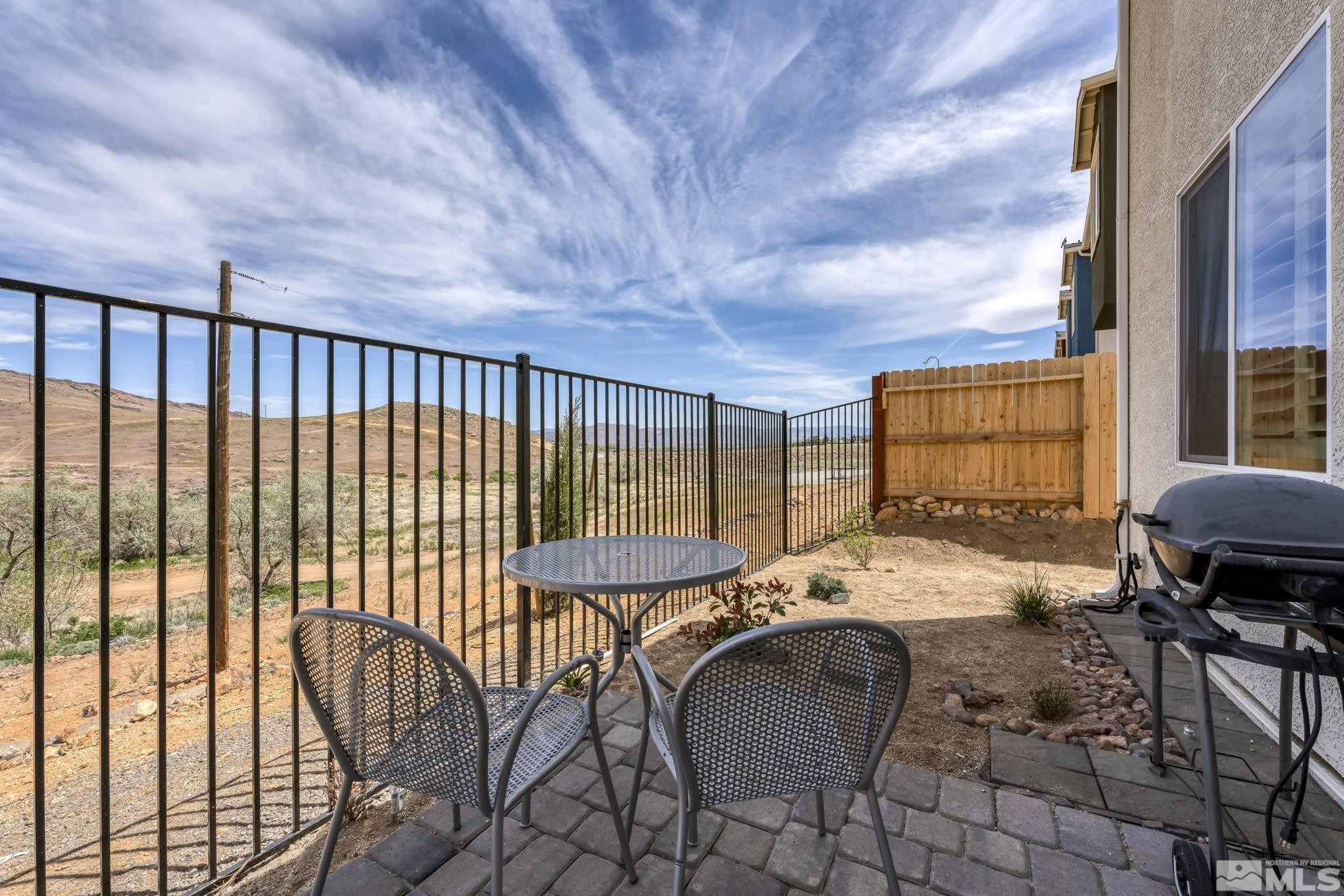 4928 Black Falcon Way Sun Valley, NV 89433 - Photo 27 of 32 a balcony with table and chairs