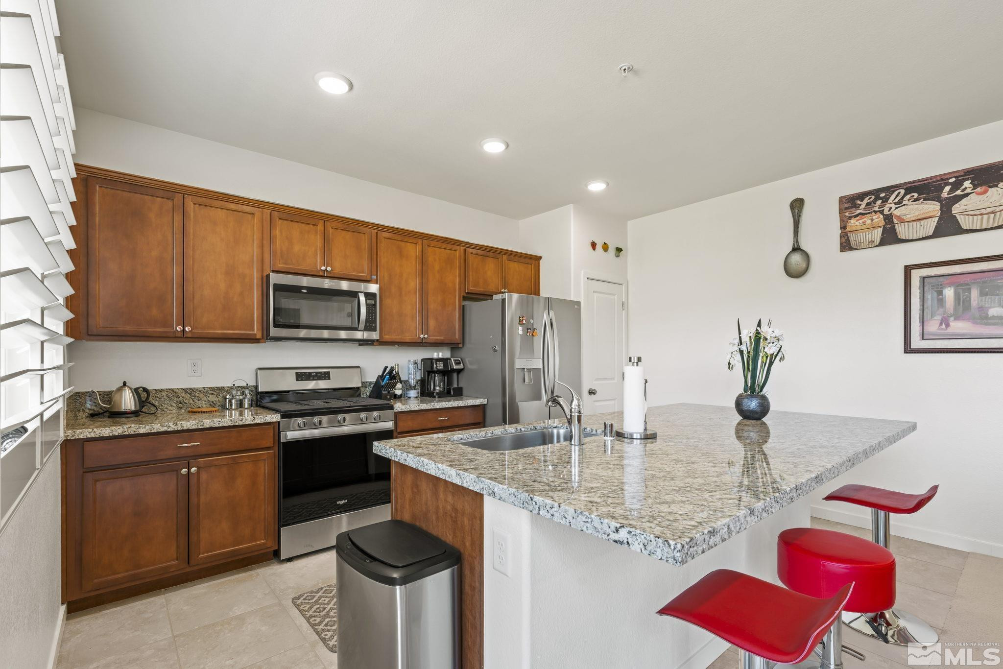 4928 Black Falcon Way Sun Valley, NV 89433 - Photo 3 of 32 a kitchen with stainless steel appliances granite countertop a sink stove and refrigerator