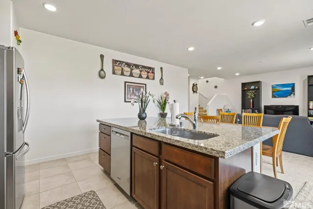 a kitchen with stainless steel appliances granite countertop a sink and a refrigerator