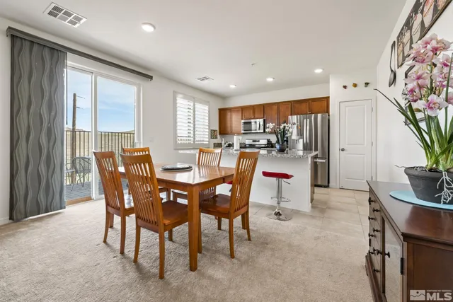 a view of a dining room with furniture and a potted plant