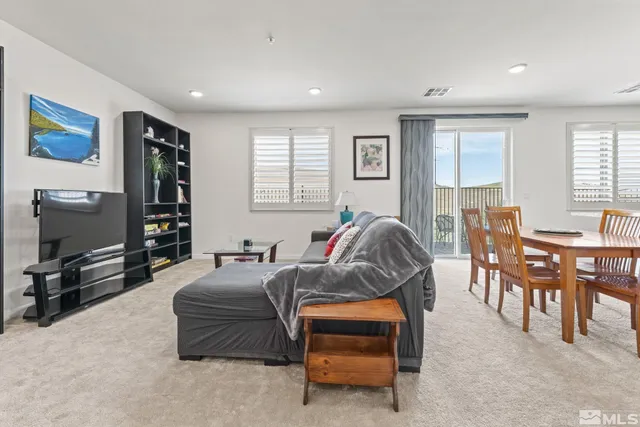 a living room with furniture a window and a flat screen tv