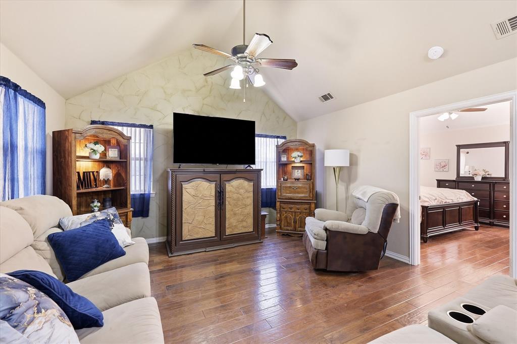 5855 Ge Horton Road Justin, TX 76247 - Photo 3 of 34 Vaulted ceiling with a ceiling fan, wood-finish flooring, and a doorway opening to another room