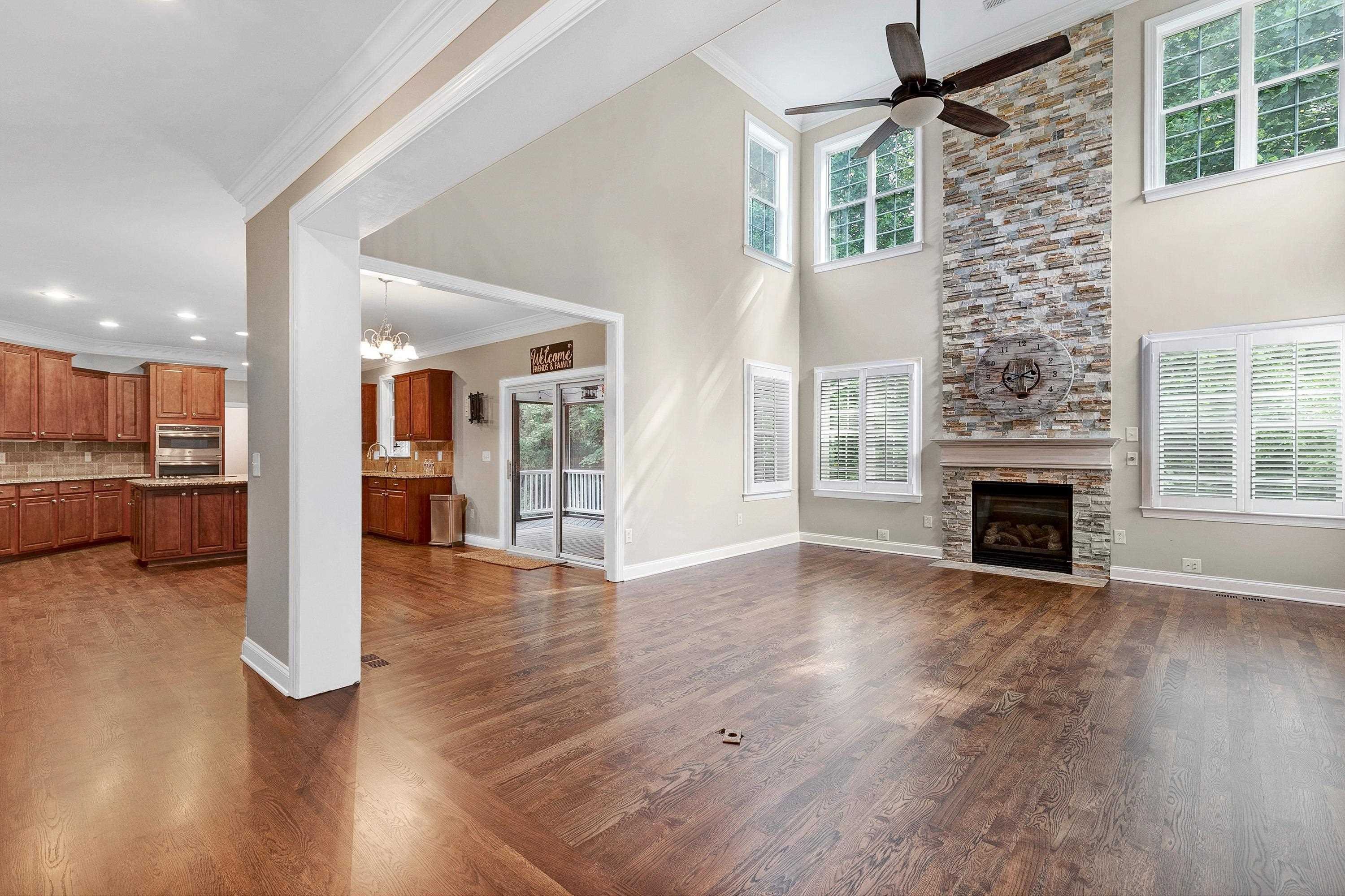 8431 Henderson Road Apex, NC 27539 - Photo 11 of 56 a view of a livingroom with wooden floor and a kitchen