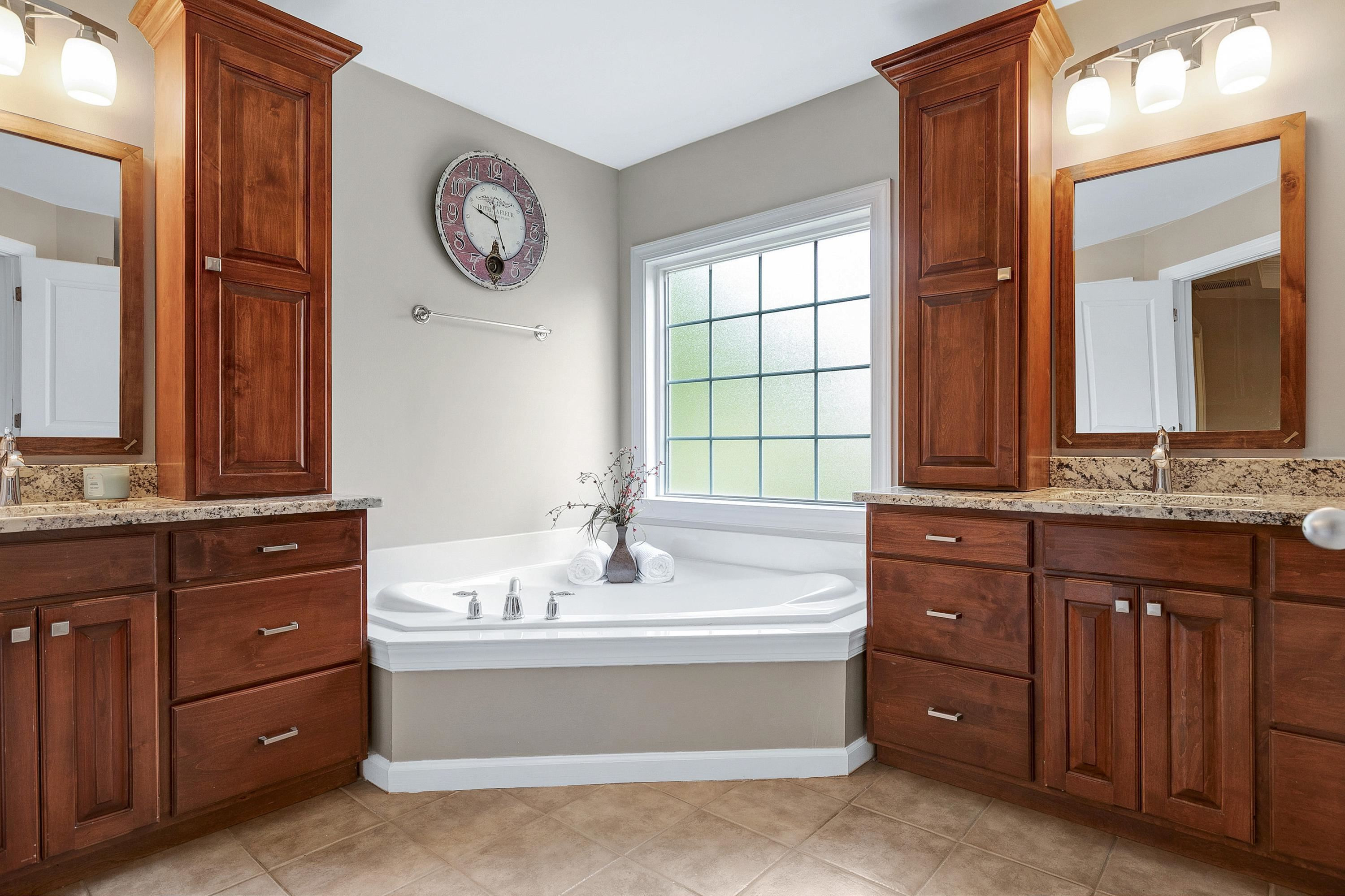 8431 Henderson Road Apex, NC 27539 - Photo 30 of 56 a spacious bathroom with a tub sink and mirror