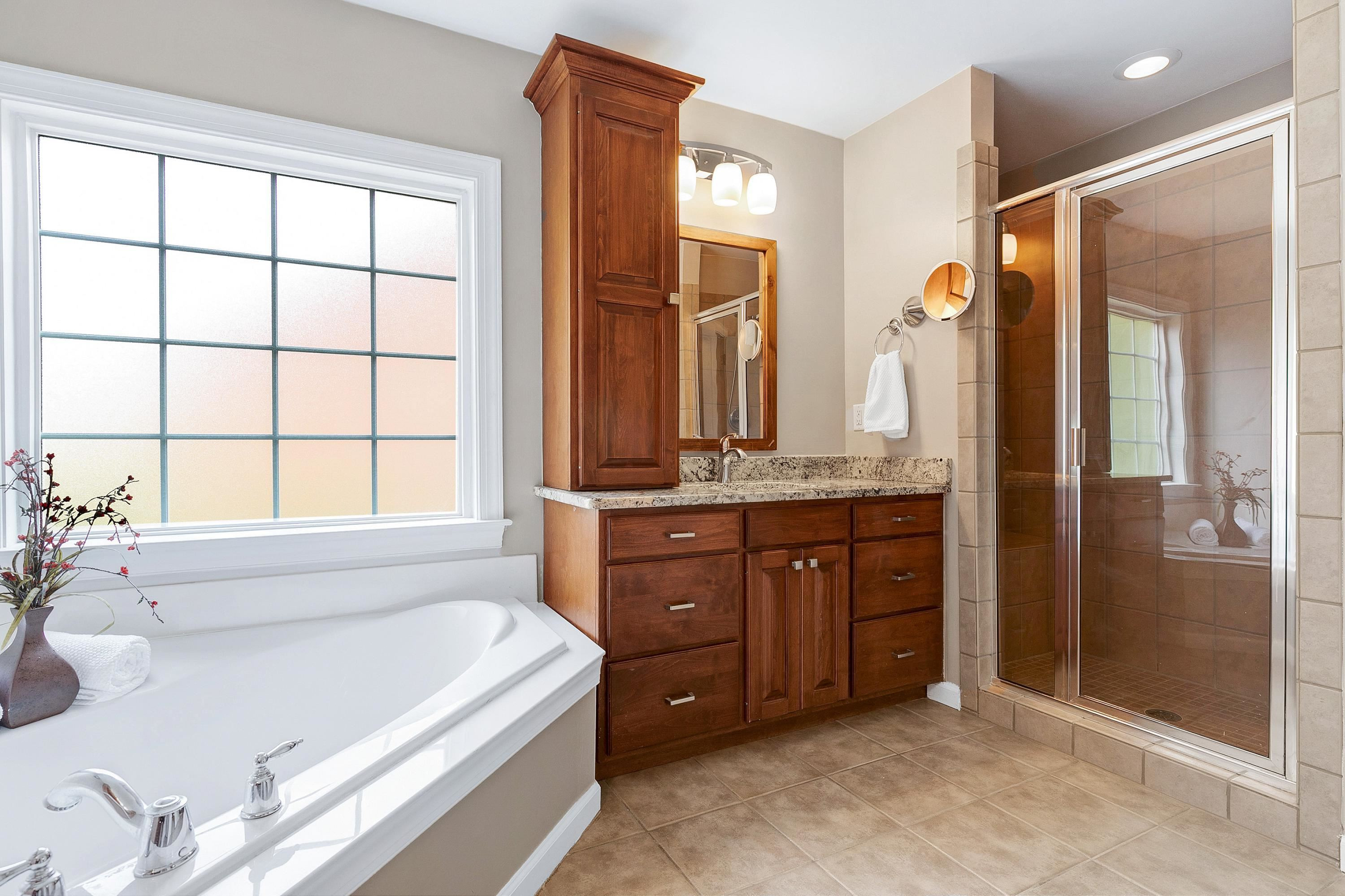 8431 Henderson Road Apex, NC 27539 - Photo 31 of 56 a spacious bathroom with a tub sink and mirror