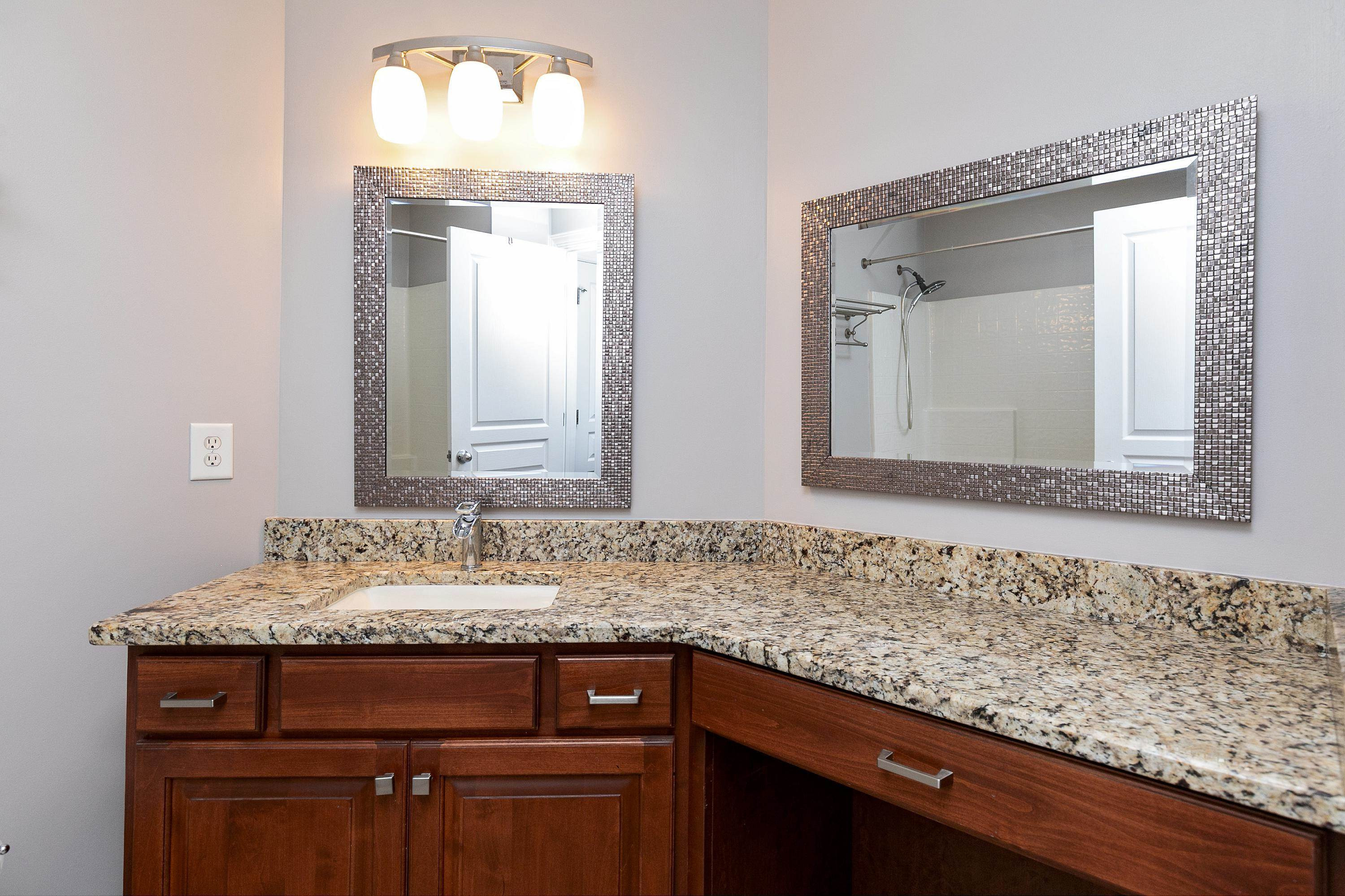 8431 Henderson Road Apex, NC 27539 - Photo 38 of 56 a bathroom with a granite countertop sink and a mirror