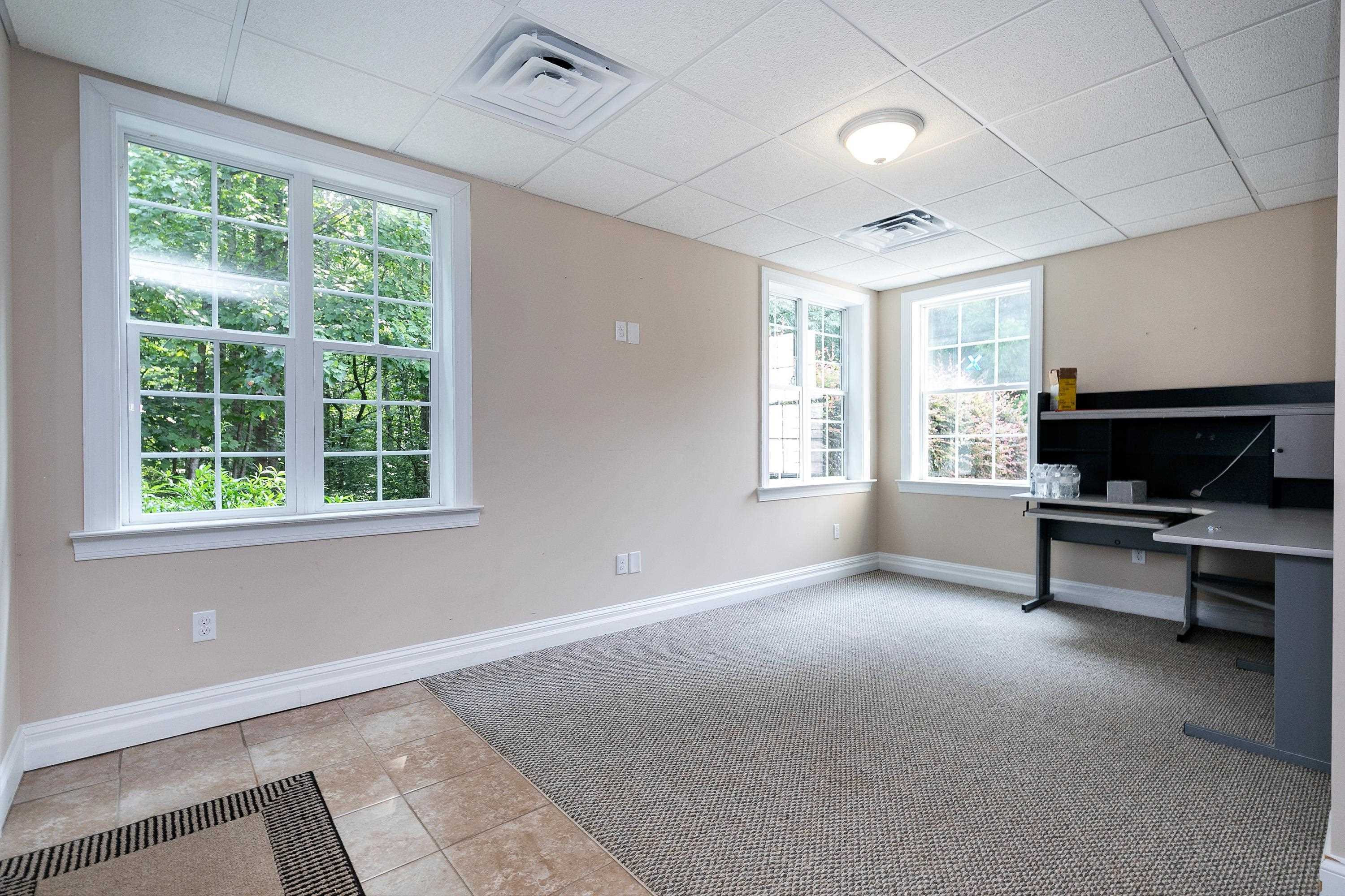 8431 Henderson Road Apex, NC 27539 - Photo 42 of 56 a living room with furniture a flat screen tv and a window
