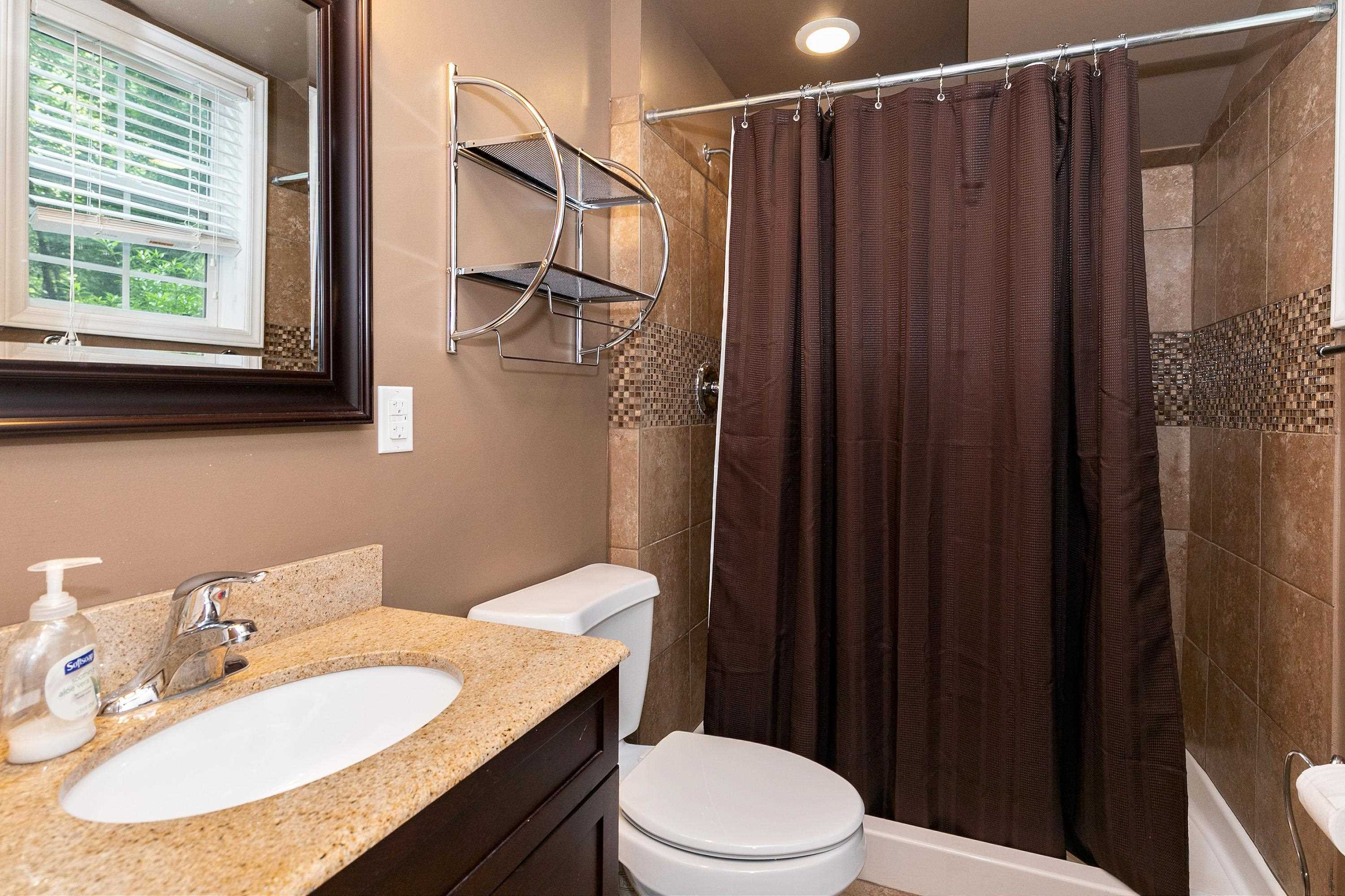 8431 Henderson Road Apex, NC 27539 - Photo 43 of 56 a bathroom with a sink vanity mirror and toilet